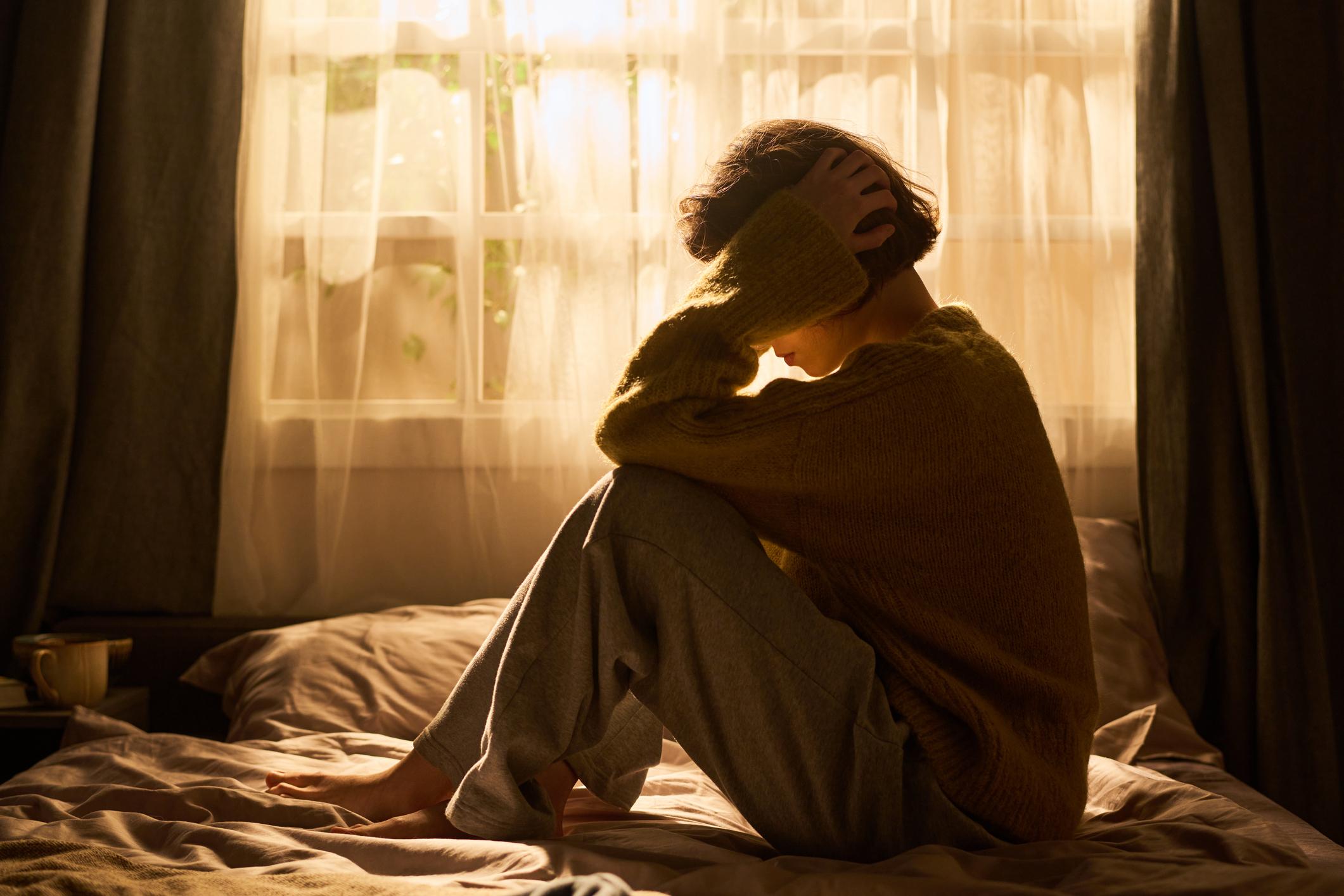 Woman Sat On Bed Tired